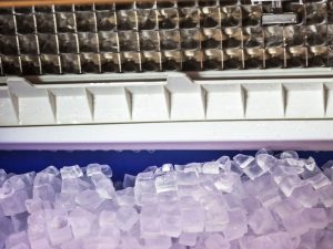 A close-up of an ice maker’s freezing mechanism with slow ice production affecting cube formation and overall machine efficiency.