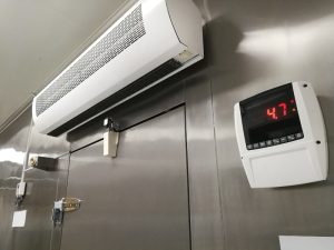 A cold room with excessive moisture evident, featuring an air conditioner and digital temperature display.