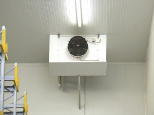 A fan unit, part of industrial refrigeration systems fail scenarios, mounted on a cool room wall.