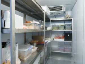 A peek inside a cold storage room, highlighting potential food spoilage if industrial refrigeration systems fail.