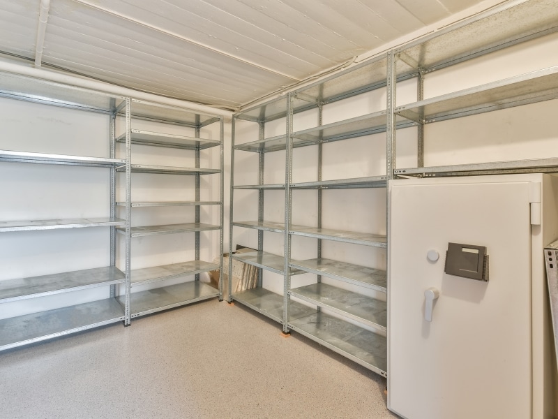 Empty cool room with metal shelves and a safe—early cool room repair signs include unused space and poor storage conditions.