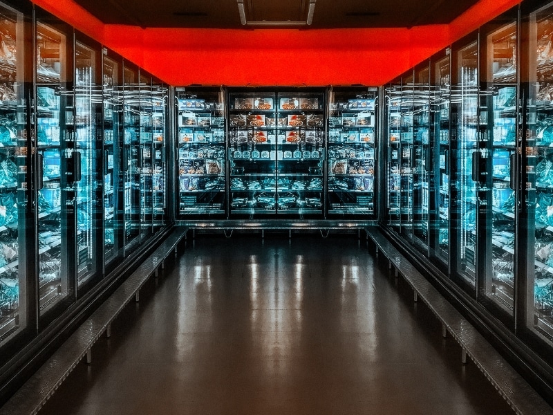 Upright glass-door supermarket fridges highlighting commercial refrigeration repair cost considerations.